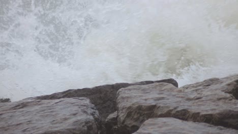 waves crashing on the rocky shore in canada - closeup shot