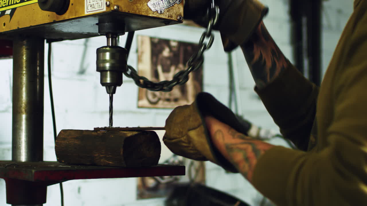 reparación mecánica y construcción. artesano tatuado perforando placa de acero