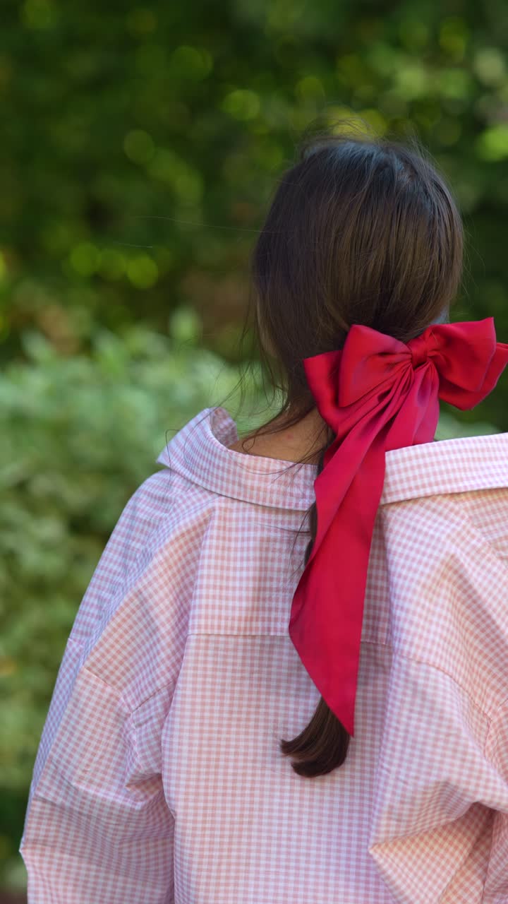 은 타이를 입은 분홍색 셔츠를 입은 여자