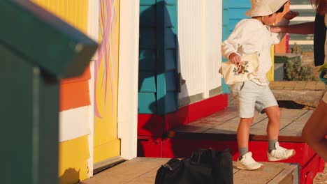 a child playing near colorful beach huts