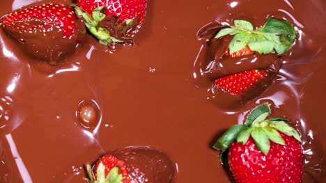 strawberries being dipped into melted chocolate