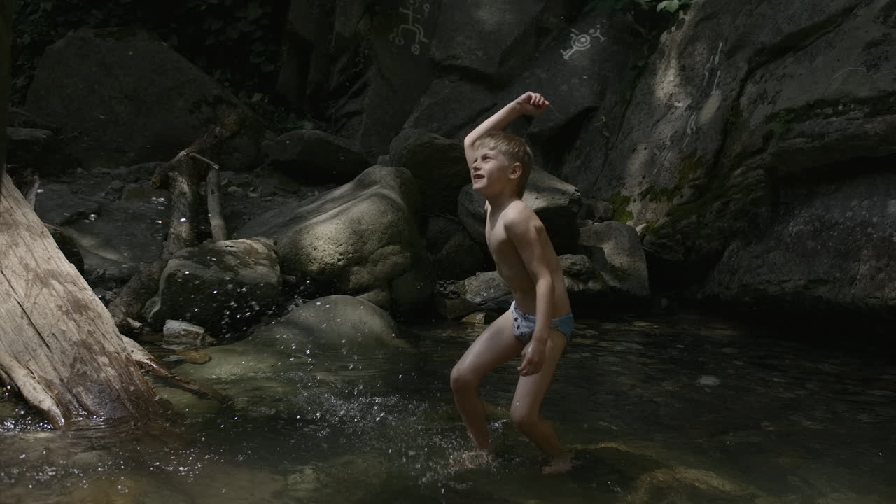 산의 하천에서 놀고 있는 소년