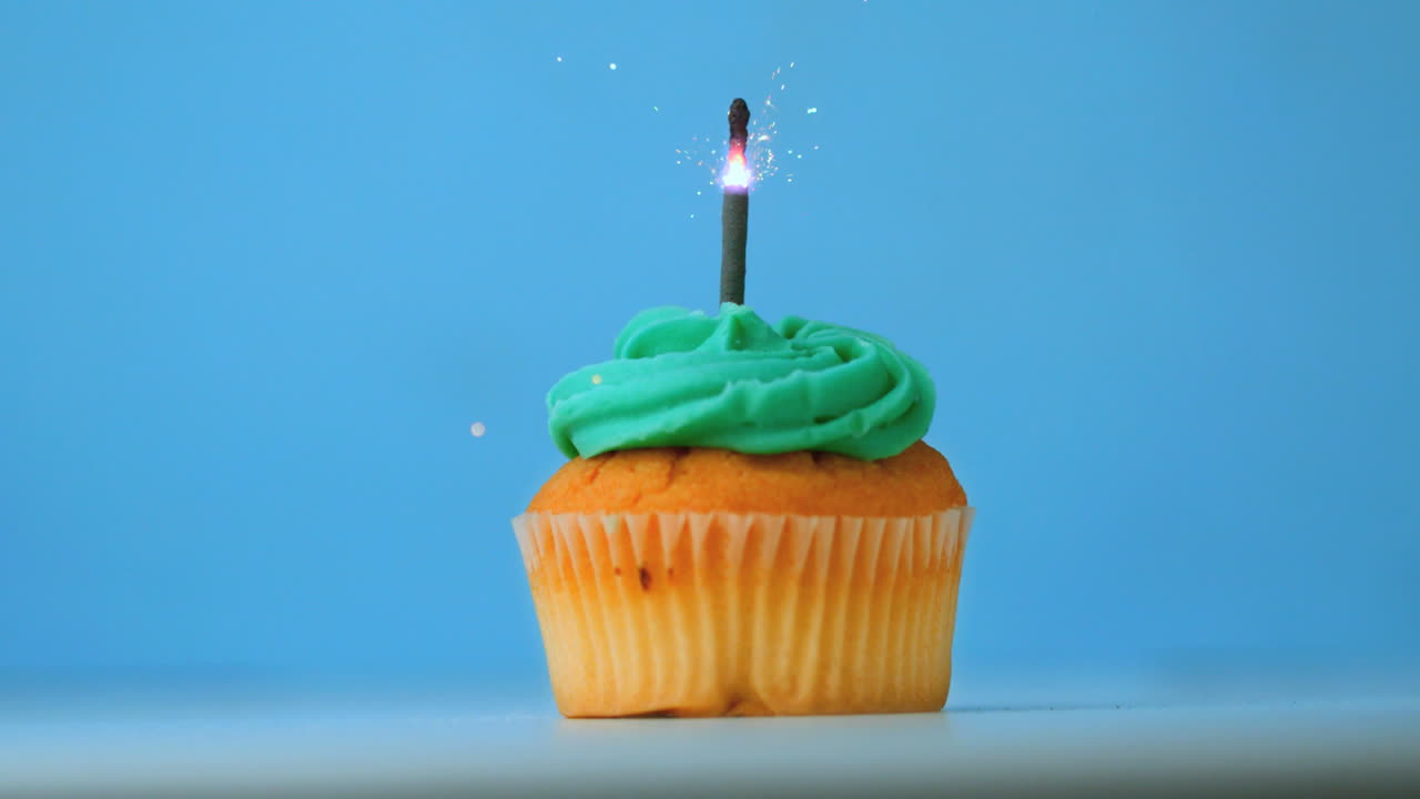 una chispa que arde en el pastel de cumpleaños azul