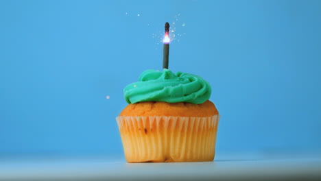 sparkler burning on blue birthday cupcake