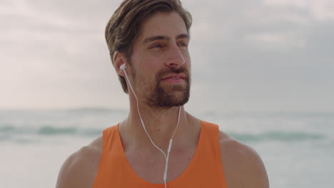 Retrato-De-Un-Hombre-Musculoso-Atractivo-Que-Usa-Auriculares-Relajándose-En-La-Tranquila-Playa-Junto-Al-Mar-Escuchando-Música-En-Forma-De-Estilo-De-Vida-Saludable-Masculino-Caucásico