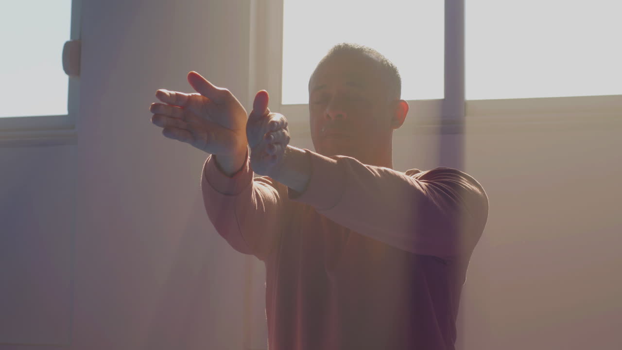 hombre con los ojos cerrados practicando tai chi en el gimnasio