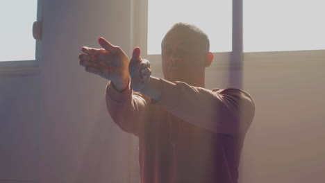 man with closed eyes practicing tai chi in gym