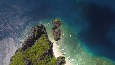 Aerial-topdown-of-rugged-cliffs,-boats-grounded-on-beach