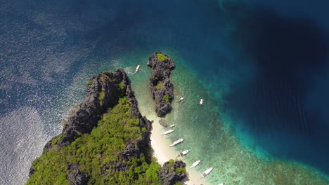 aerial topdown of rugged cliffs, boats grounded on beach