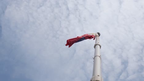 doblada mientras vuela hacia la izquierda durante un día nublado, bandera filipina