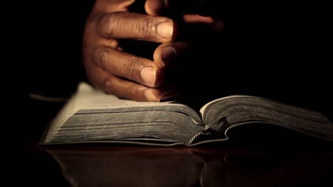 praying with hand on bible on black background with people stock footage