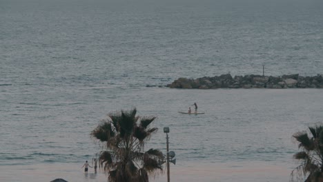 Tabla-De-Paddle-Navegando-A-Lo-Largo-De-La-Orilla-Del-Mar