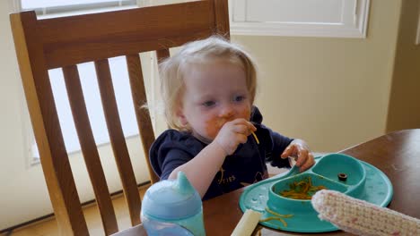 adorable niño comiendo espagueti con las manos tiene una cara desordenada y graciosa