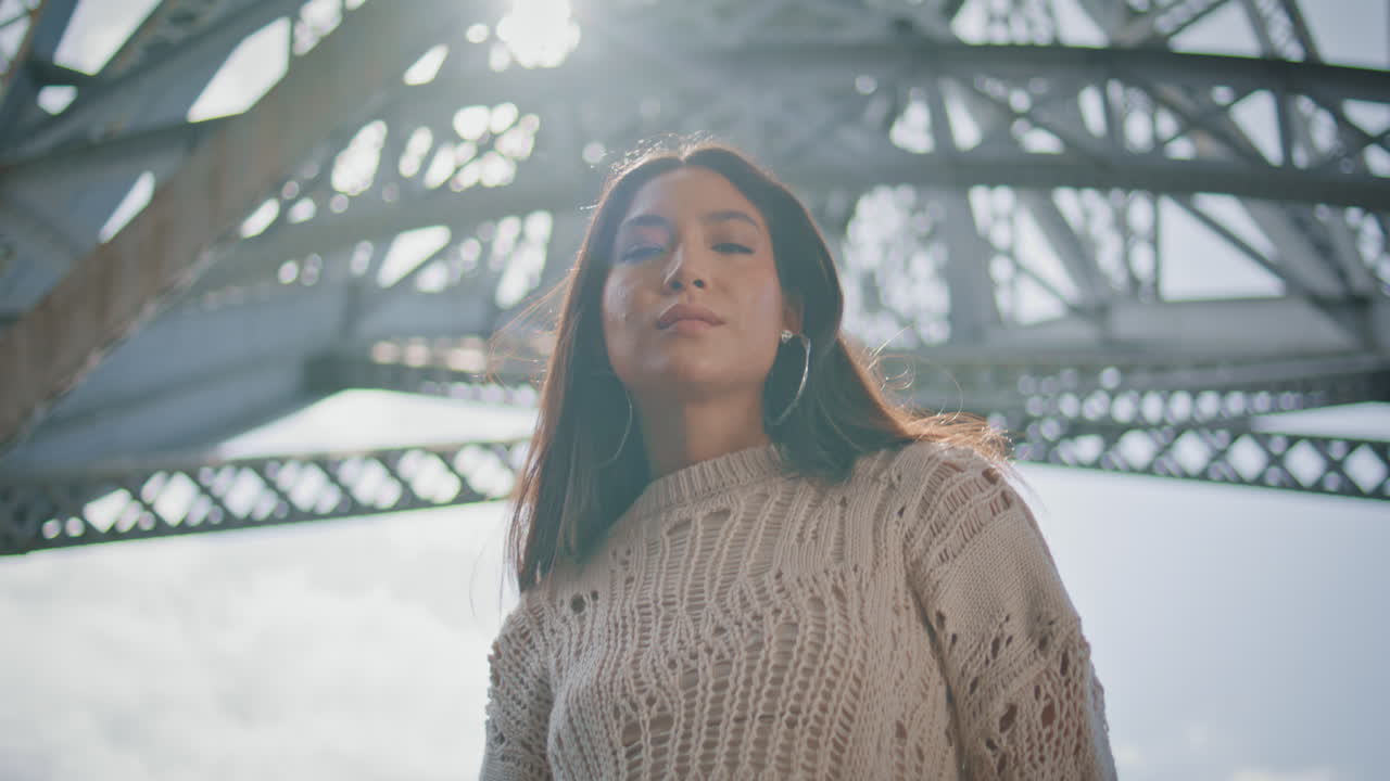 Model posing sunlight iron bridge construction looking camera portrait