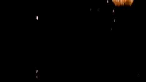 golden churros fall onto a dark surface, scattering sugar crystals in dramatic slow motion. high-contrast lighting and a black background emphasize texture and movement