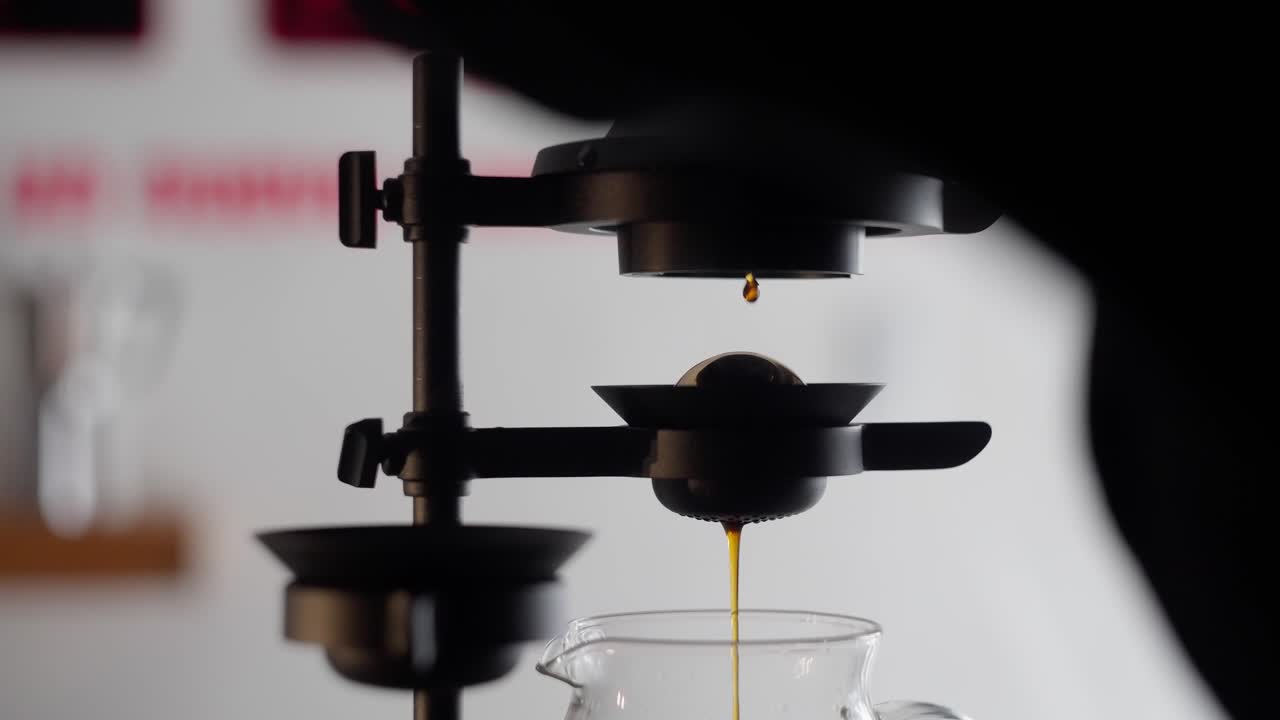 Close up view in slow motion of coffee drops falling in a jar