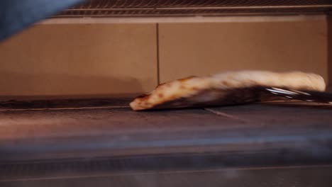 Close-up-on-pizza-being-baked-inside-pizza-oven