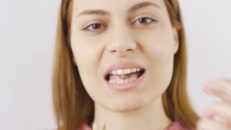 una mujer comiendo pistacho en primer plano.