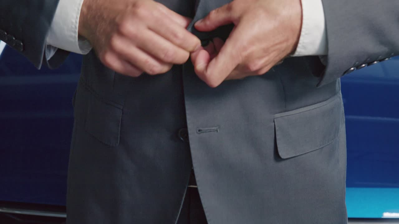 close up de hombre botón de la chaqueta mientras estaba de pie en el salón de automóviles