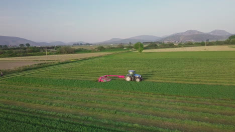 Farmer-driving-tractor-plows-field-in-rural-Greece-during-sunset,-4K