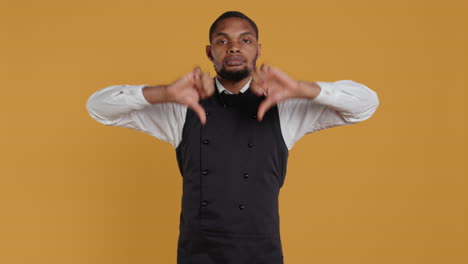 Serious-displeased-waiter-gives-a-thumbs-down-sign-in-studio