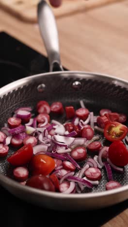 sautéing onions, sausages, and tomatoes