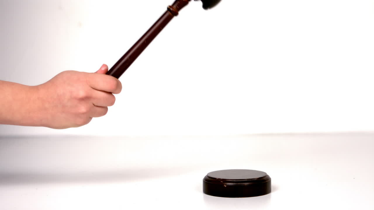 Close up of hand banging a law hammer on the gavel