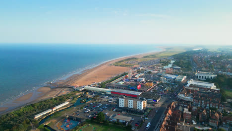 presenciar el encanto de skegness, una joya costera en lincolnshire, a través de imágenes aéreas, con su vasta playa, animada zona turística, atracciones de la feria, y el muelle icónico en una noche de verano