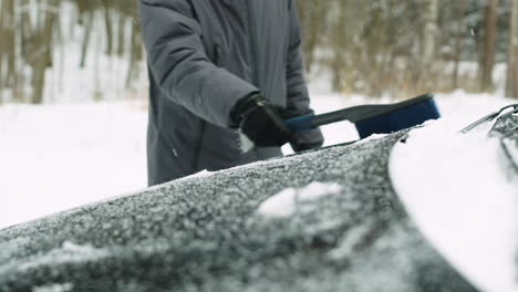 Close-Up-Of-An-Unrecognizable-Man-Cleaning-His-Car-From-Snow-With-A-Brush-In-A-Winter-Day