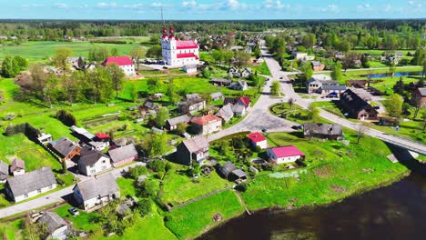 aerial shot of a tranquil village in lithuania, showcasing houses and lush green fields