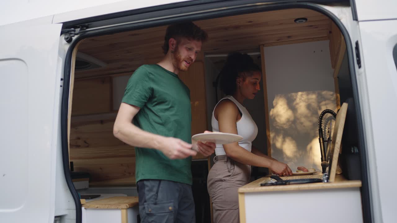People cooking food inside a van