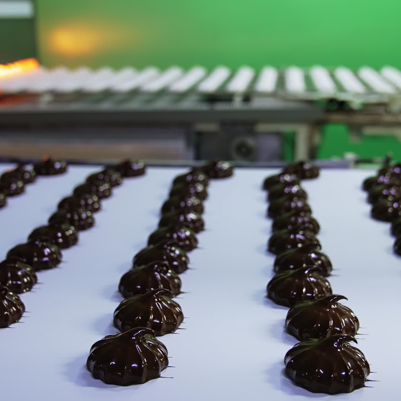 Chocolate covered marshmallows on a conveyor belt