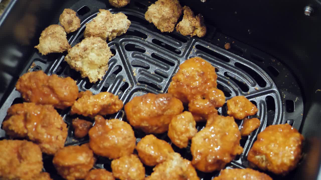 Revealing of cauliflower buffalo bites in air fryer being prepared to cook