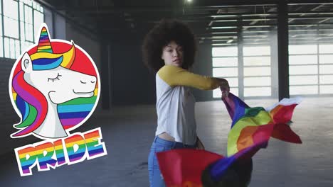 animation of rainbow pride and unicorn over african american woman with rainbow flag