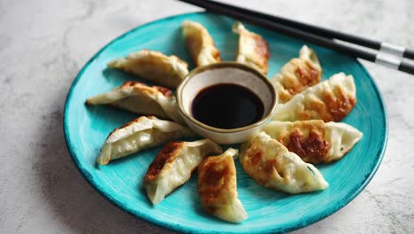 albóndigas asiáticas tradicionales gyozas en plato de cerámica turquesa