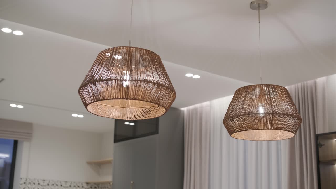 두 개의 짜여진 펜던트 조명은 우아하게 매달려 있으며, 현대적인 방에 따뜻하고 질감있는 조명을 방출하며, 자연적인 요소와 현대적인 디자인을 혼합합니다.