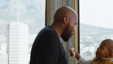 vater und sohn essen bananen in der küche zu hause 4k