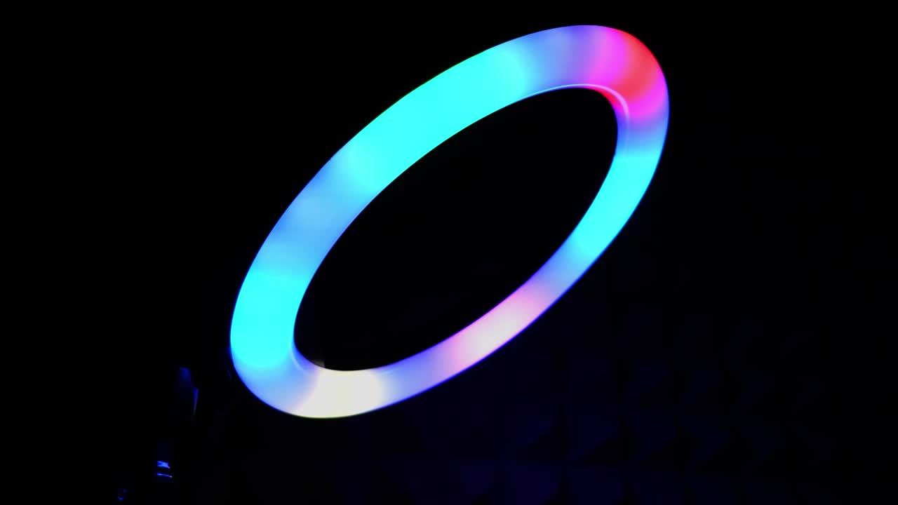 Luminous ring rgb lamp. Multicolored light in a dark room, close-up.