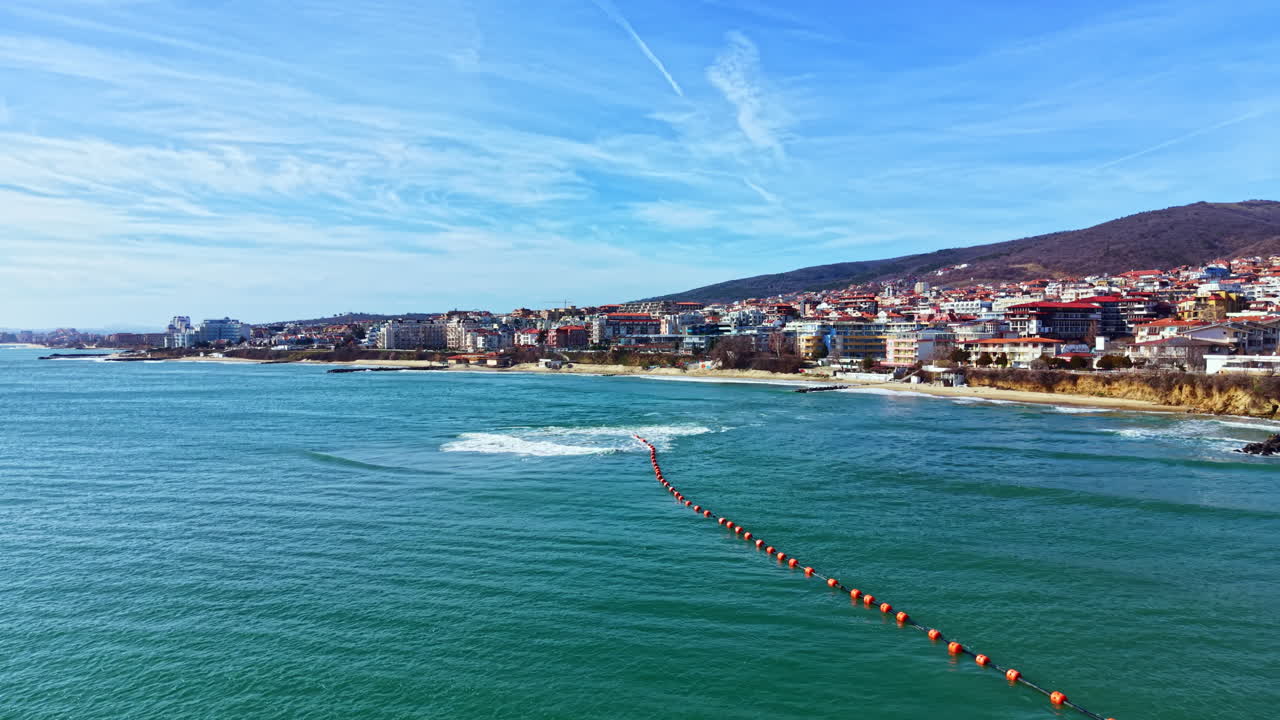 Acqua limpida in spiaggia con edifici lungo la costa in una giornata di sole in riva al mare in una città costiera