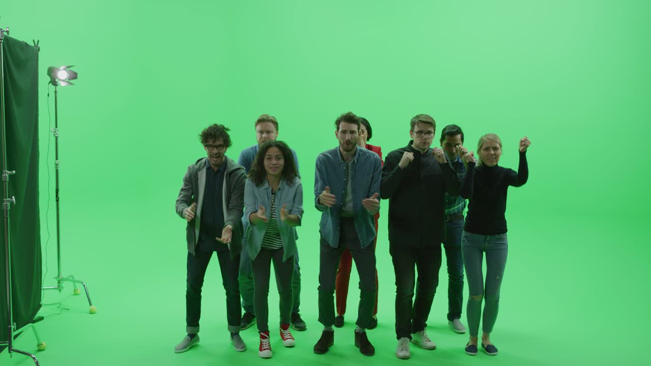 그린 스크린 크로마 키 스튜디오: 대중 스포츠 행사, 콘서트, 페스티벌, 파티에서 다민족 팬들의 다양한 군중이 환호하고, 뛰어내리고, 공중에서 손을 들어 박수를 치고 있습니다.