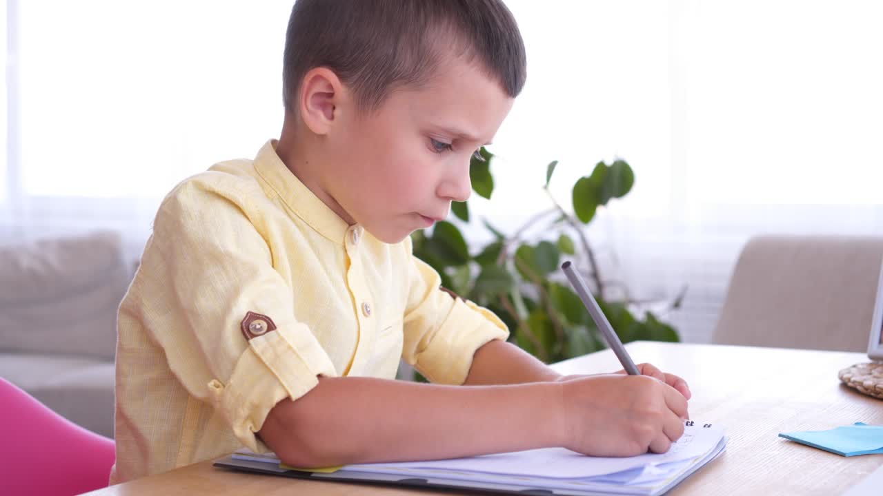 부지런 한 소년 이 사본 책 에 뭔가 쓰고 있다