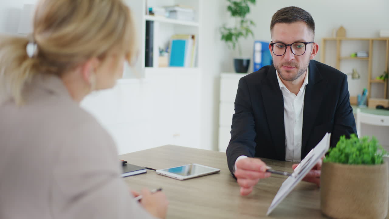 Real Estate Agent Presents Offer During Meeting