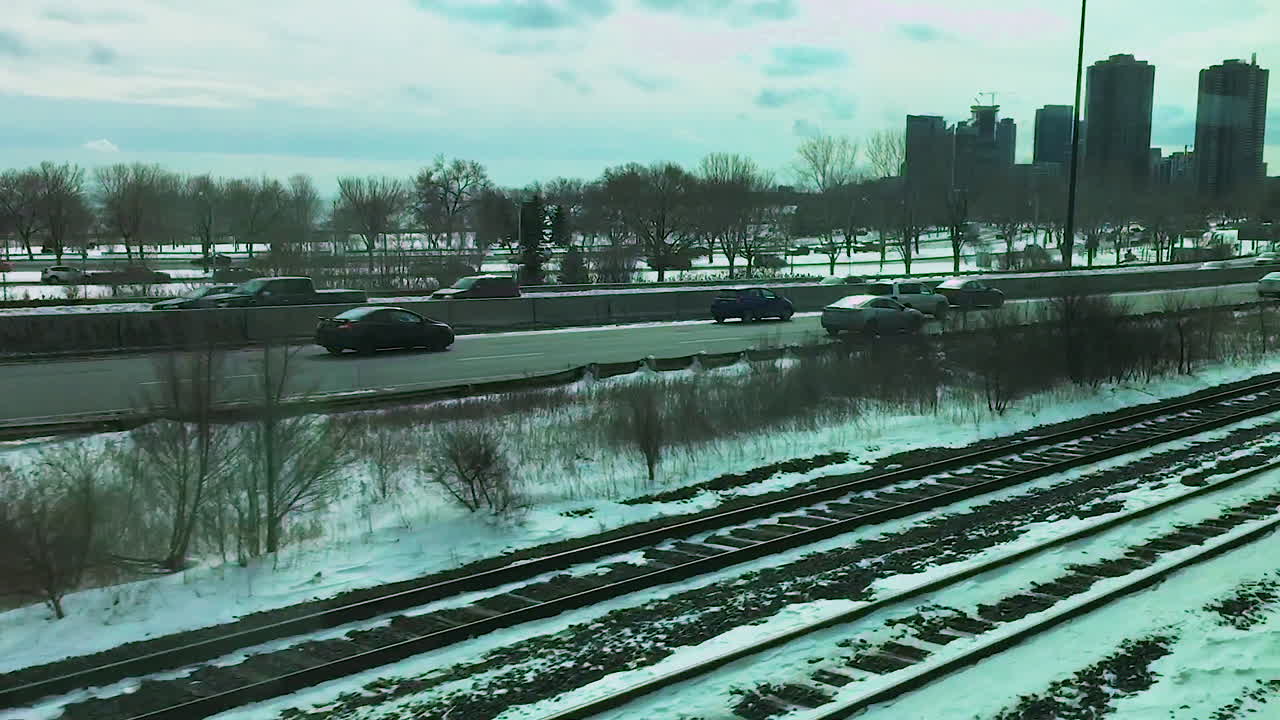 Footage of cars driving down the highway during a snowy winter.