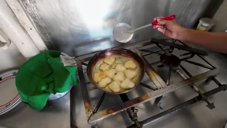 Arepa-frying-in-a-heart-shaped-pan,-Venezuelan-typical-food,-top-down-rustic-kitchen