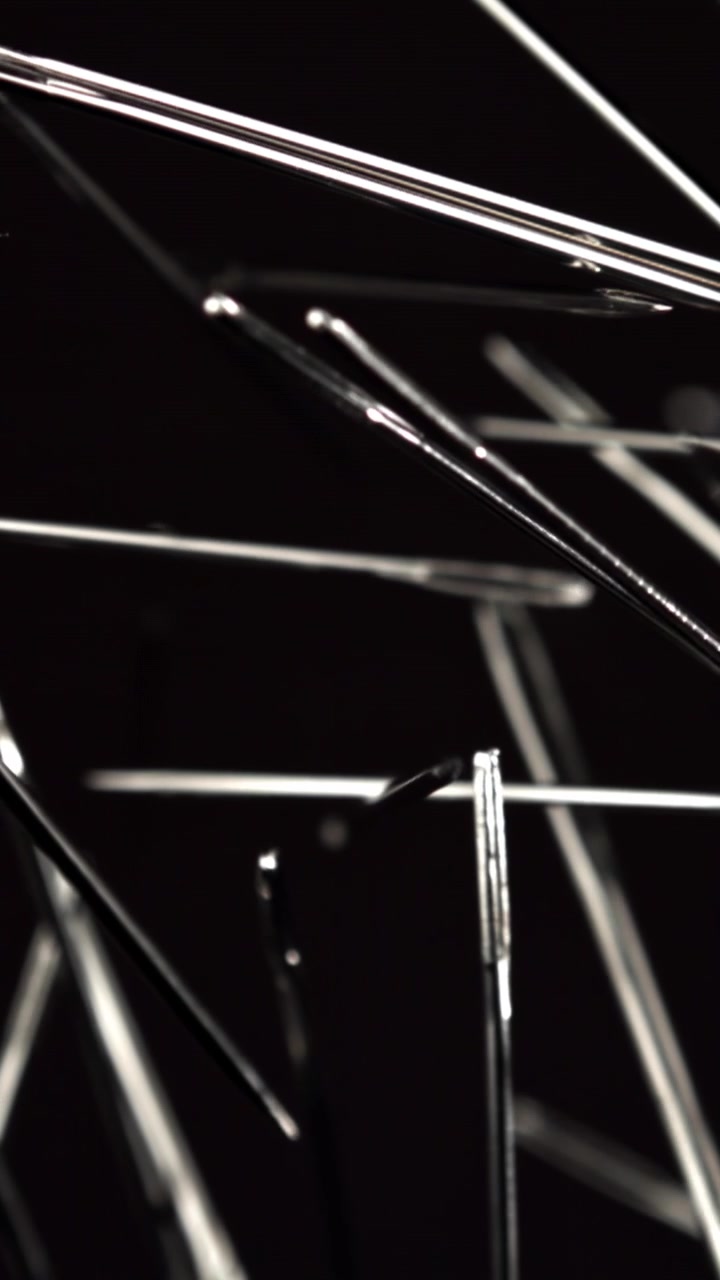 Sharp Metal Sewing Needles Focusing on a Black Surface