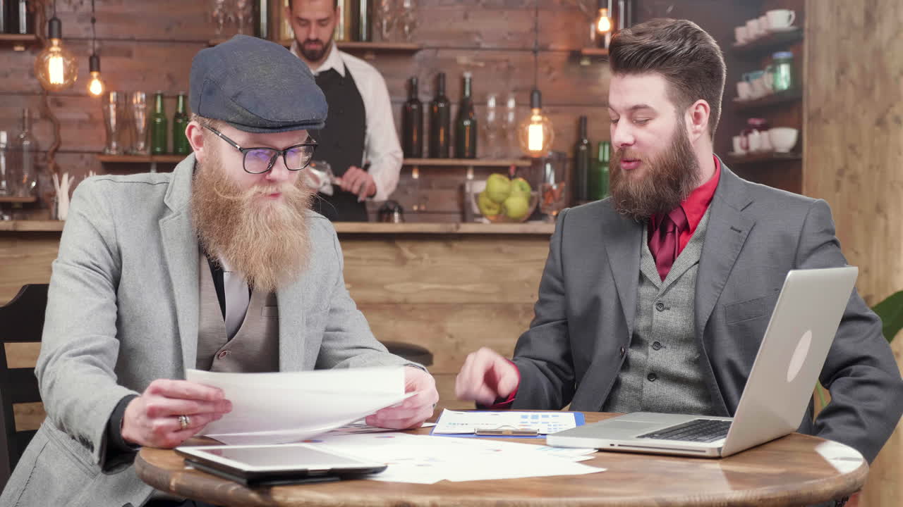 Forretningsfolk diskuterer finansielle diagrammer i en bar