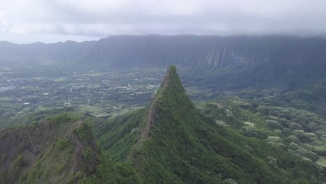 jagged mountain cliff edges covered in koa trees and greenery in hawaii kai east honolulu, aerial tilt dolly