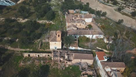 Aerial-view-of-an-abandoned-village-with-a-church-surrounded-by-nature-in-Spain