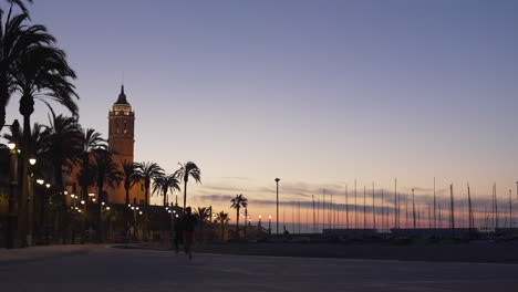 paseo marítimo puesta de sol de verano en la ciudad costera europea, silueta hombre corre muelle