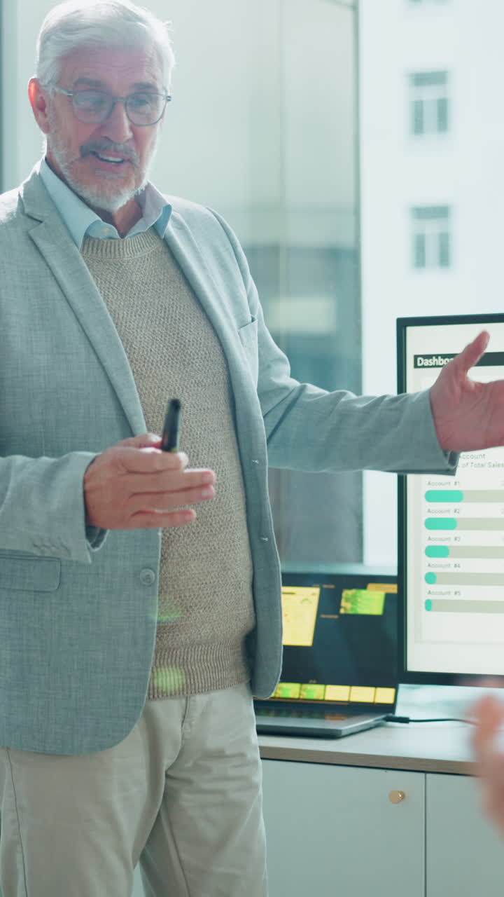 Dirigente senior presenta dati di vendita su monitor in un ufficio moderno